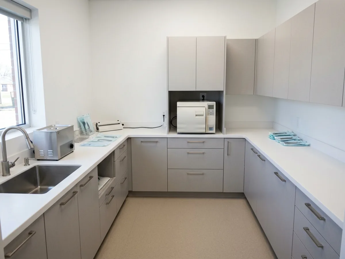Dental sterilization center with a long casework run moving from a sink and ultrasonic cleaner to packaging counter to closed storage